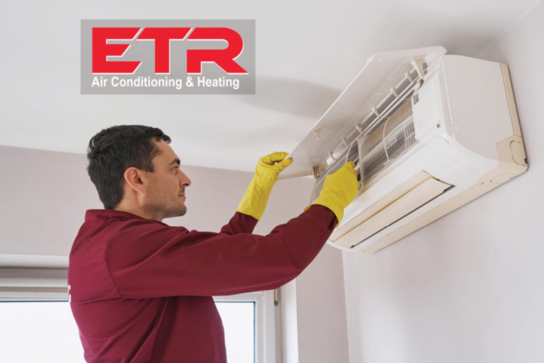 Logotipo de ETR y un hombre limpiando un mini split AC sin conductos