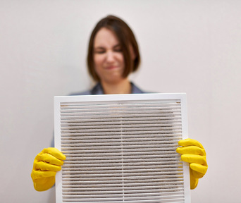 woman cleans air conditioning filter