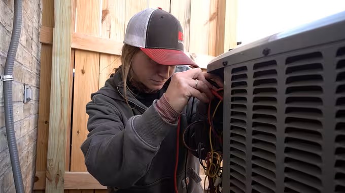 hvac technician inspecting an ac unit