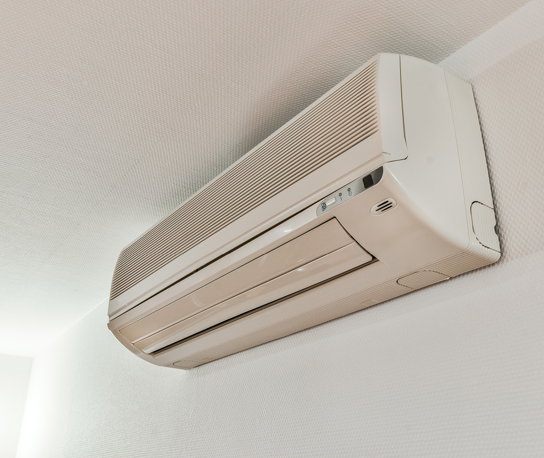 Wall-mounted ductless mini-split air conditioner indoor unit near the ceiling